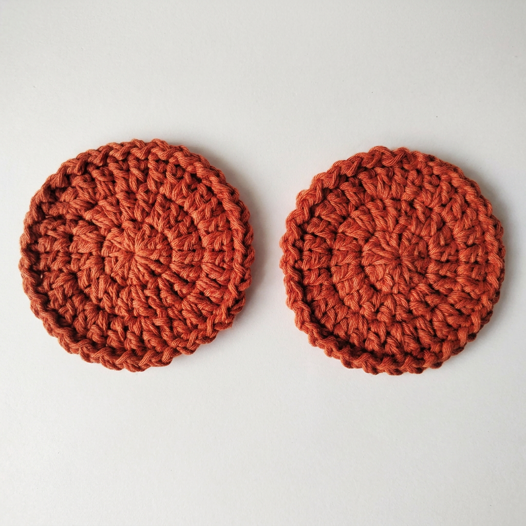 Terracotta round crochet coasters flat lay on a white table